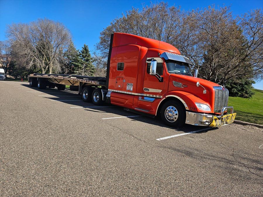 Delta Carrier Group red-orange Peterbilt 579 unit 1211 parking