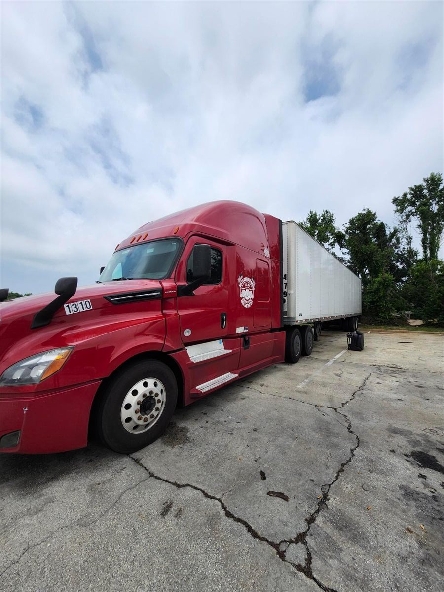 Delta Carrier Group red Freightliner Cascadia (new gen) unit 1310 parking