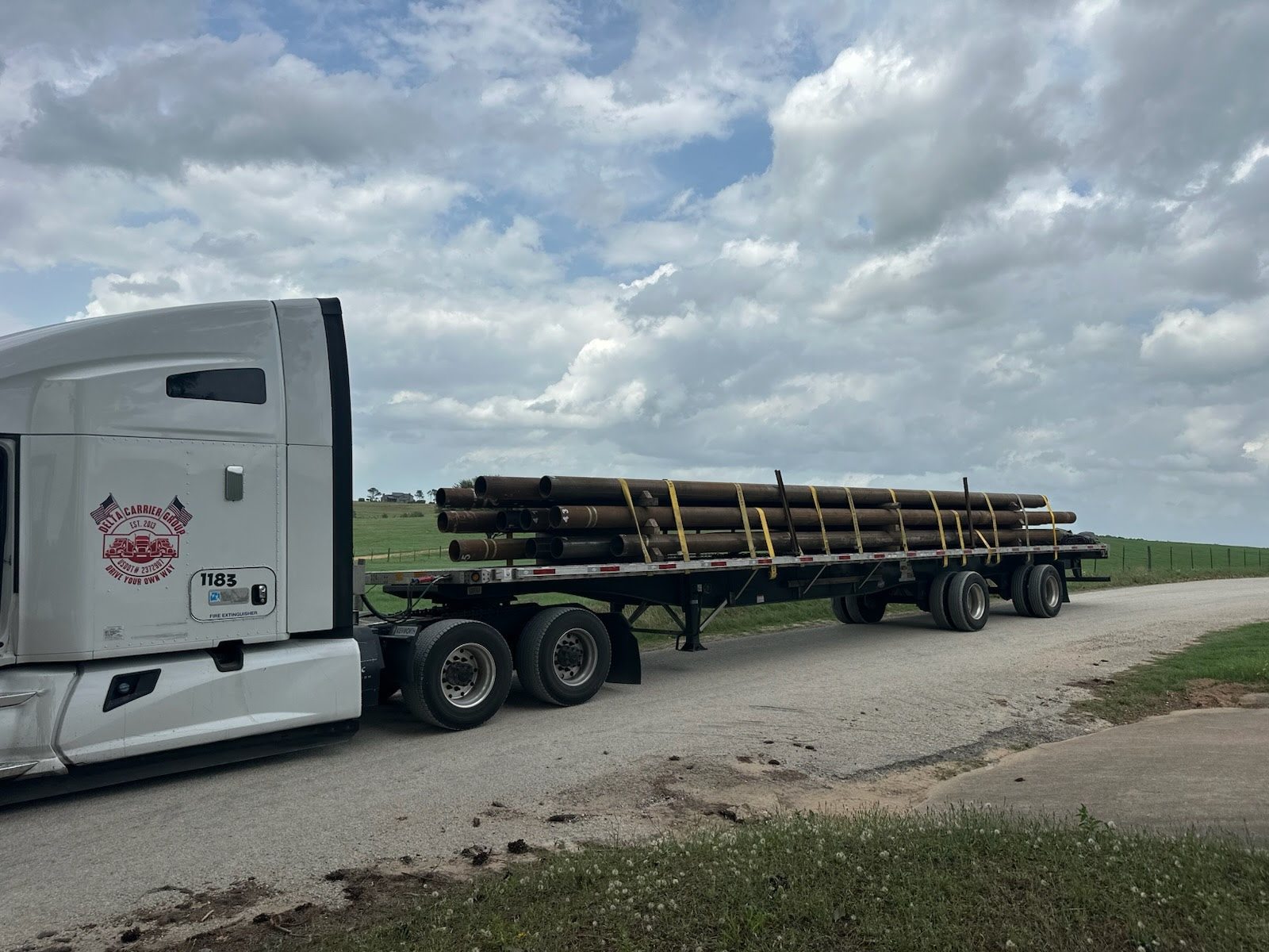 Delta Kenworth with a strapped and secured flatbed load, unit 1183