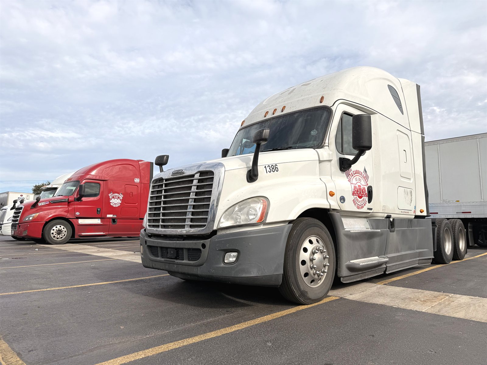 White Freightliner Cascadia with Delta badge beside a dry van trailer at the Rockdale yard, unit 1386