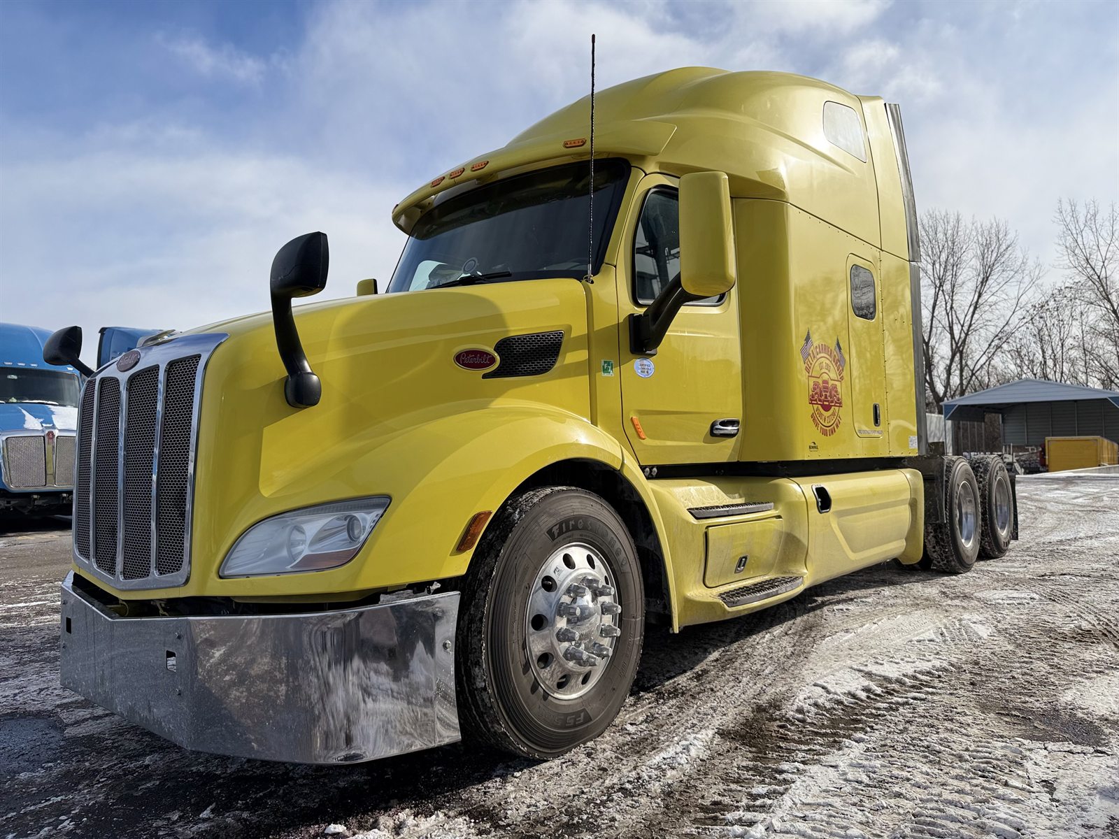 Yellow Peterbilt 579 with Delta badge, dramatic winter angle